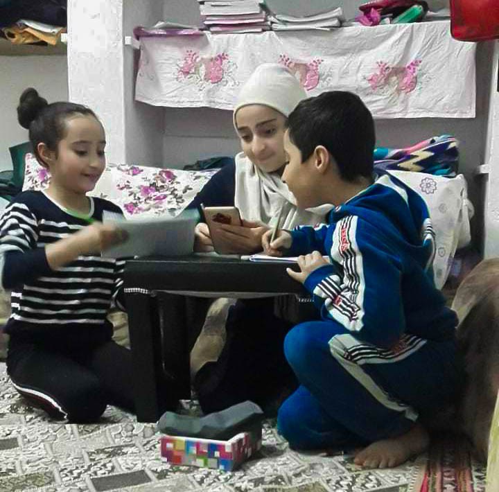 Three children learning through a smartphone