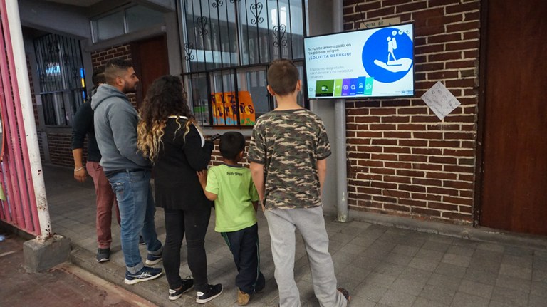 Migrants in Mexico City watching the screen installed by TSF 